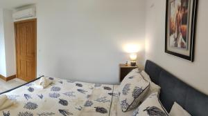 a bedroom with a bed with blue and white pillows at Apartman Linda in Milna
