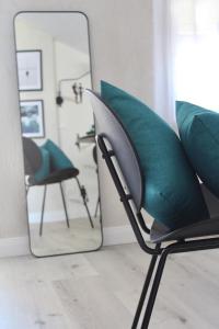 uma cadeira com um espelho num quarto em ROOFTOP A casa di Tatta - apartments by the sea em Francavilla al Mare