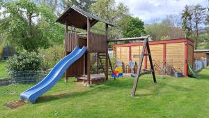 een speeltuin met een glijbaan en een speelhuis bij Ferienhaus Hesse im Frau Holle Land in Germerode