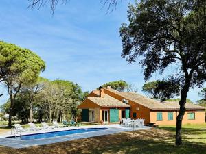 een huis met een zwembad ervoor bij Finca els pins in Llagostera