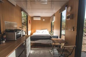 a small bedroom with a bed in a tiny house at Pirates Retreat in Eaglehawk Neck