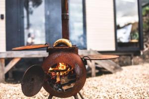 a rusty stove with a fire inside of it at Pirates Retreat in Eaglehawk Neck