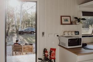 a kitchen with a view of a car outside a window at Noosa Tiny Home in Ringtail Creek