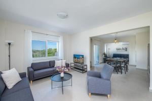 a living room with a couch and chairs and a table at Nimarevi Apartment in Soroni