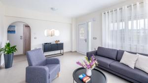 uma sala de estar com um sofá, uma cadeira e uma mesa em Nimarevi Apartment em Soroni