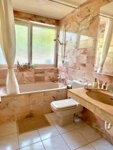 a bathroom with a tub and a toilet and a sink at Exquisites Apartment + Terrasse in Korb