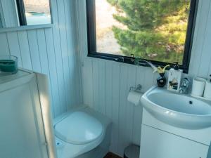 a bathroom with a toilet and a sink and a window at Blue Gum at Aranya Acres in Bungendore