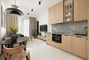 a kitchen with a table and a living room at JTB Brama Portowa in Szczecin