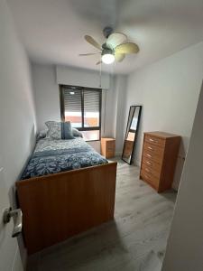 um quarto com uma cama e uma ventoinha de tecto em APARTAMENTO LA CALETA II em Caleta De Velez