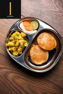 una bandeja de comida con alimentos para el desayuno en una mesa en Icyhotels sunrise 92, en Noida