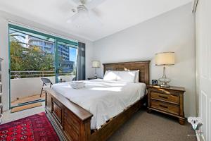 克罗纳拉KozyGuru Cronulla 1 Bed Apt next to Beach的一间带大床和窗户的卧室