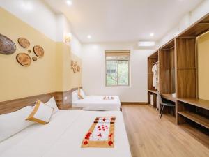 um quarto com duas camas com um bolo em Gia Cat Long Hotel em Ilha de Cát Bà