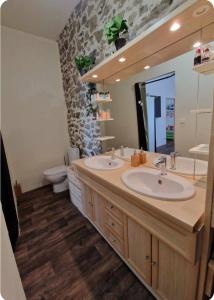 a bathroom with two sinks and a toilet at Détente en Pays d'Urfé in Saint-Marcel-dʼUrfé