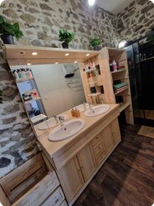 a bathroom with two sinks and a large mirror at Détente en Pays d'Urfé in Saint-Marcel-dʼUrfé