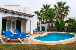 a patio with two chairs and a swimming pool at Apartchalet villas Elvira. Villa E in Son Carrio