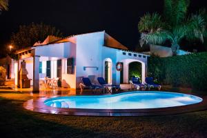 a villa with a swimming pool at night at Apartchalet villas Elvira. Villa E in Son Carrio
