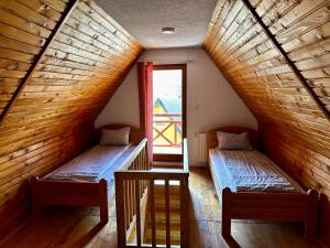 two beds in a room with a window at Holiday home Krajina I in Vlasic