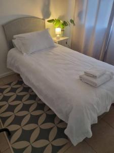 a bed with white sheets and towels on it at Lanaria 9, Betty's Bay in Clareport