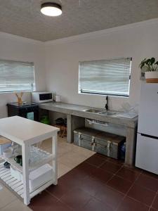 a kitchen with a table and a white refrigerator at Lanaria 9, Betty's Bay in Clareport