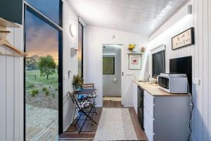 a tiny house with a kitchen and a counter with a microwave at Left Field Tiny House in Ashbourne