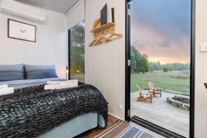 a bedroom with a bed and a sliding glass door at Left Field Tiny House in Ashbourne