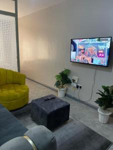 uma sala de estar com um sofá e uma televisão de ecrã plano em Lulu’s staycations Tsavo em Nairobi