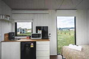 uma cozinha com um balcão com um lavatório e uma cama em Bella Views em Heathcote