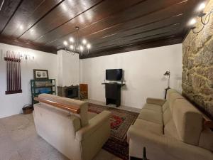 un salon avec un canapé et une cheminée dans l'établissement Casa do Capitão de Cutelo - Gerês, à Terras de Bouro