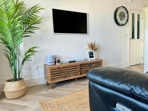 Μια τηλεόραση ή/και κέντρο ψυχαγωγίας στο Luxury Sea View Apartment with Multi Room Balcony And Private Onsite Parking Only 300M From the Beach
