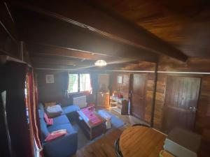 a living room with a blue couch and a table at Mon Chalet dans les bois in Villard-Saint-Sauveur