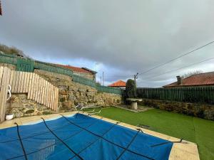 een achtertuin met een blauw volleybalveld in een tuin bij Casa do Capitão de Cutelo - Gerês in Terras de Bouro