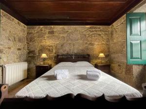 une chambre avec un lit avec deux oreillers dessus dans l'établissement Casa do Capitão de Cutelo - Gerês, à Terras de Bouro 49 autres photos