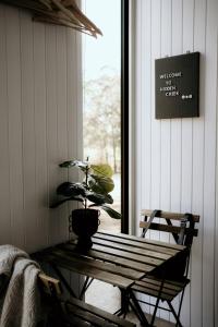 stół z doniczką siedzącą obok okna w obiekcie Hidden Creek Tiny Home w mieście Kurrajong