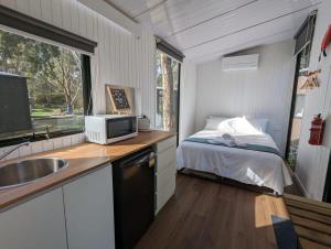 a small kitchen with a bed in a tiny house at Tiny House 4 at Grampians Edge in Dadswells Bridge