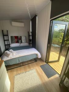 a bedroom with a bed and a sliding glass door at Hill Creek 2 Tiny House in Perwillowen