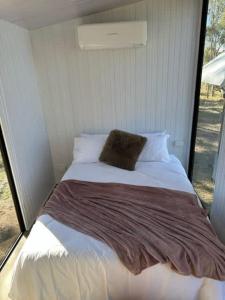 un letto con un cuscino in una stanza di The Retreat Tiny House a Lagoon Pocket