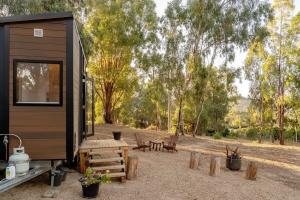 a tiny house with a picnic table and benches at Summer Lea 2 in Howes Creek