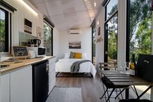 ein Schlafzimmer mit einem Bett und eine Küche mit einem Tisch in der Unterkunft Summer Lea 2 in Howes Creek