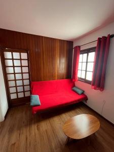 a room with a red couch and a table at Studio Grenal - JK Bem Localizado in Porto Alegre