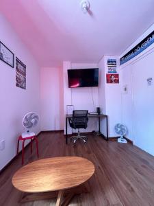 een kamer met een tafel en een bureau met een computer bij Studio Grenal - JK Bem Localizado in Porto Alegre