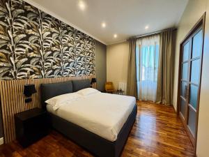 1 dormitorio con 1 cama y una gran pintura en la pared en La Fontana Luxury Apartment en Nettuno