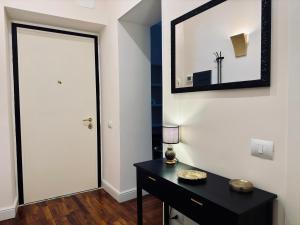 un pasillo con una cómoda negra y una puerta blanca en La Fontana Luxury Apartment en Nettuno