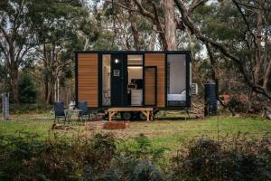 a tiny house in a field with a table and chairs at Northern Grampians Getaway in Dadswells Bridge