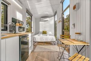 a kitchen with a table and a bed in a room at Northern Grampians Getaway by Tiny Away in Dadswells Bridge