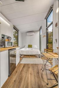 a bedroom with a bed and a kitchen with a table at Northern Grampians Getaway in Dadswells Bridge