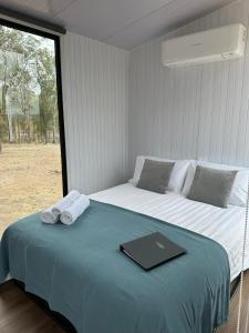 - une chambre avec un lit et un livre dans l'établissement The Retreat Tiny House 2, à Lagoon Pocket