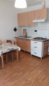 a kitchen with a table and a stove top oven at Appartamenti La Rosa dei Venti in Lacona