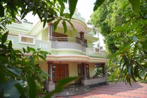 a yellow house with a balcony on top of it at Ashiaana Homestay in Trichūr