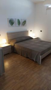 a large bed in a room with two lamps at Appartamenti La Rosa dei Venti in Lacona