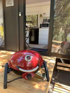 a red appliance sitting on a table in a kitchen at Tiny House Elevation 156 in Amamoor